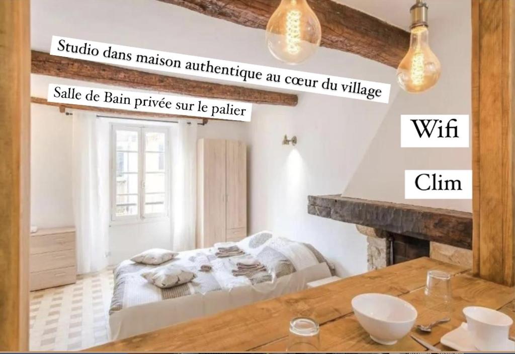 une chambre avec un lit et une table en bois dans l'établissement AUTHENTIQUE STUDIO au CŒUR du VILLAGE PROVENCAL, à Villeneuve-Loubet