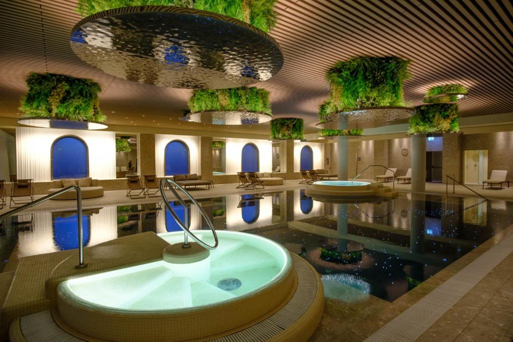 阿巴諾泰爾梅的住宿－Hotel Mioni Pezzato，带浴缸和游泳池的大型浴室