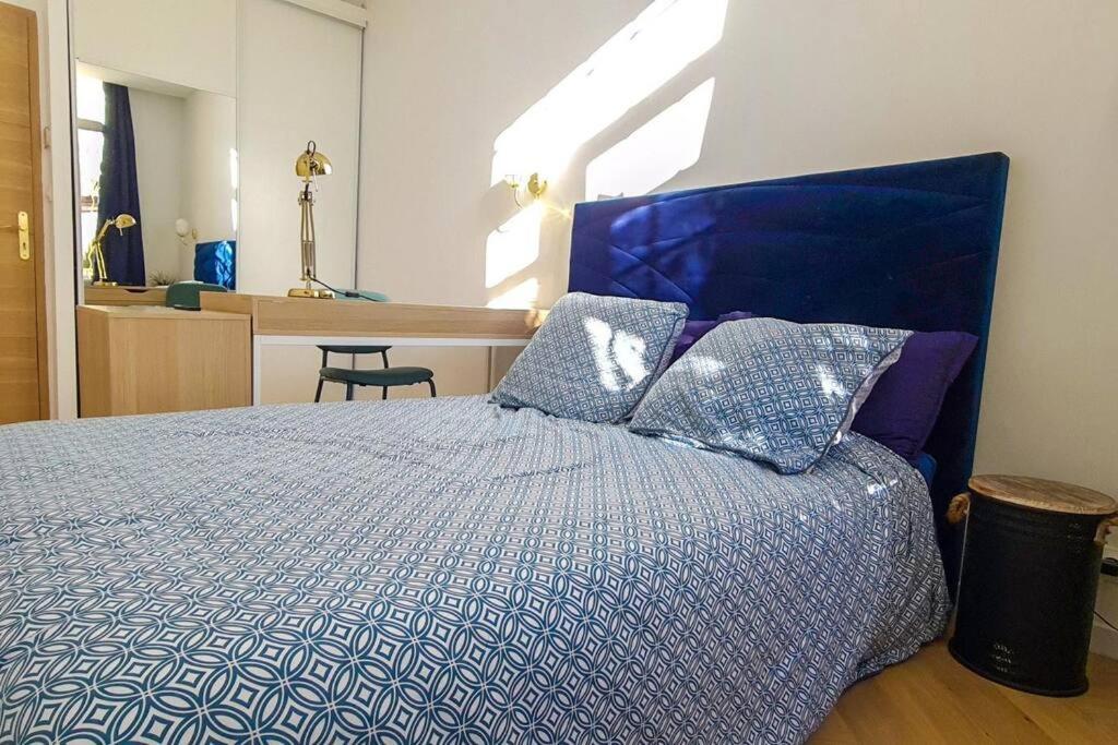 a bedroom with a blue bed with pillows on it at Luxury apartment with sea view in Marseille