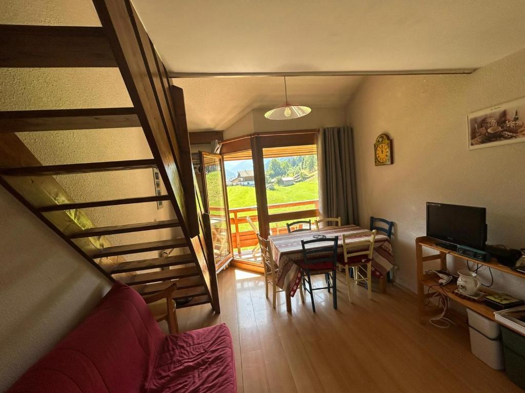 a living room with a table and a dining room at Appartement Morzine, deux pièces, mezzanine, 4 personnes in Morzine