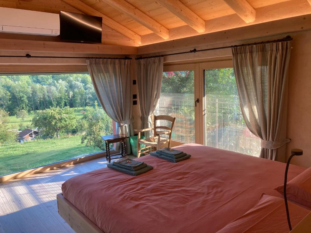 sypialnia z łóżkiem i dużym oknem w obiekcie Antico fienile w mieście Belluno