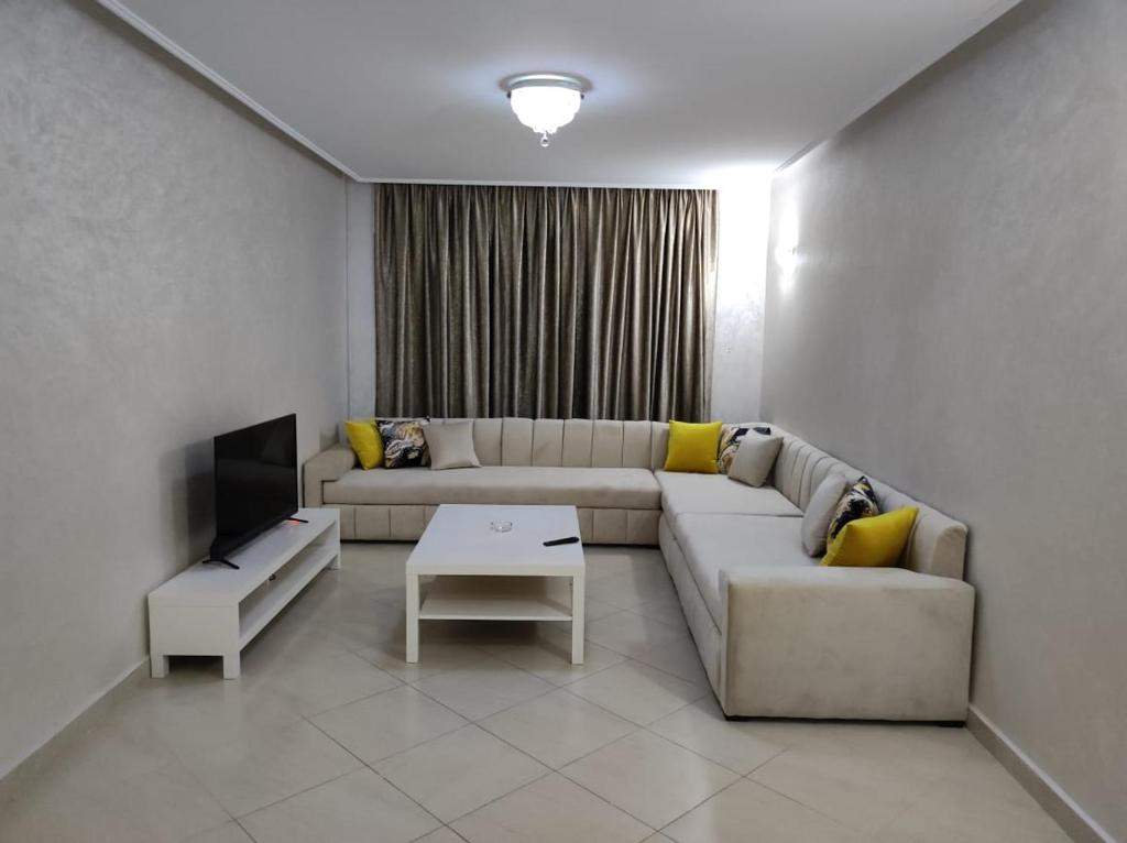 uma sala de estar com um sofá e uma televisão em Centre Réception tanger près de la plage em Tânger