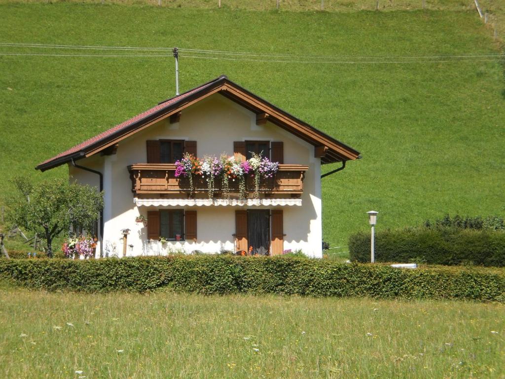 a house with a balcony with flowers on it at Gästehaus Schwed in Wagrain