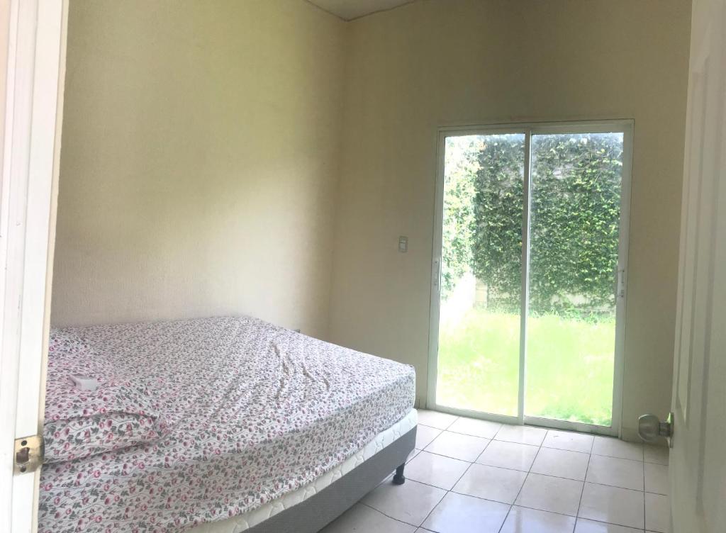 ein Schlafzimmer mit einem Bett und einem großen Fenster in der Unterkunft shaylas in Santa Ana