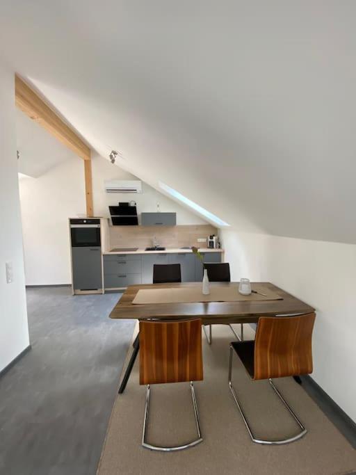 a room with a table and chairs and a kitchen at Ferienwohnung Louis in Passau
