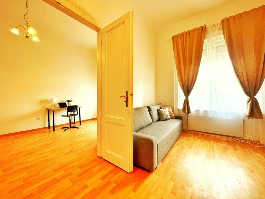 een woonkamer met een bank en een raam bij Central Spacious Flat in Boedapest