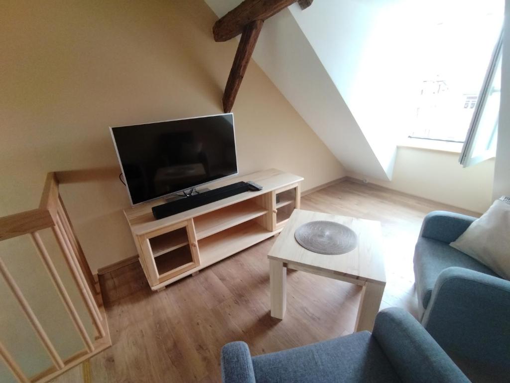 a living room with a tv and a couch at Schmal & Hoch - Willkommen im schmalsten Haus von Bad Frankenhausen in Bad Frankenhausen