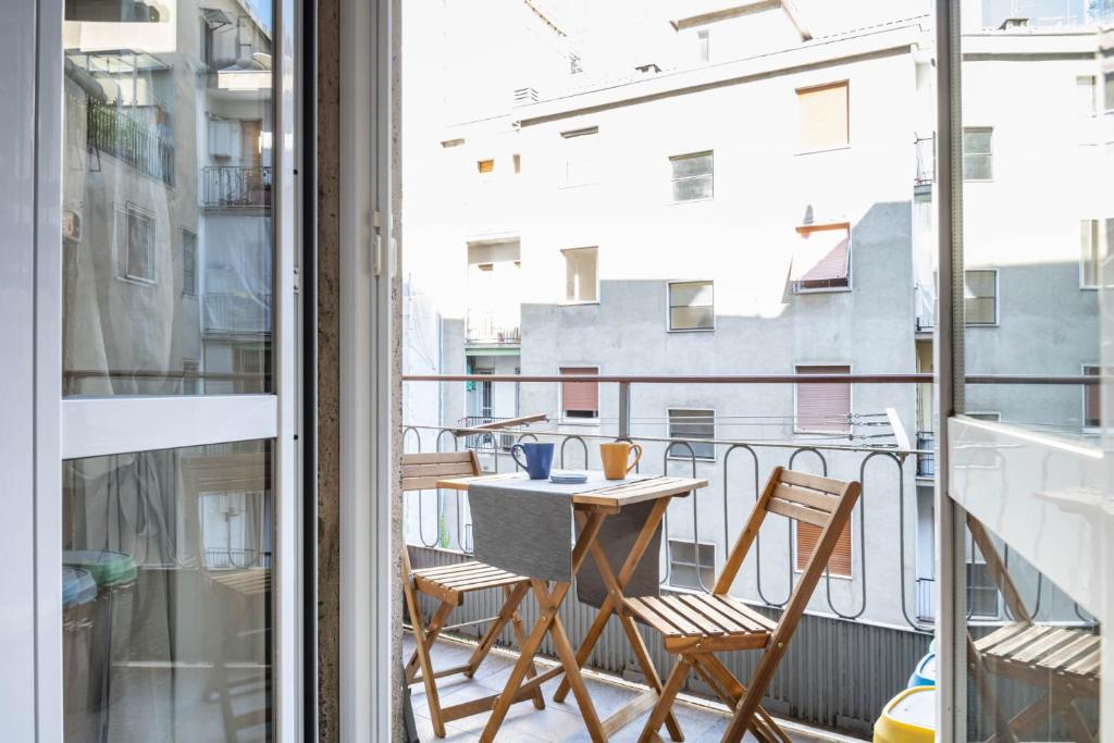 a balcony with a table and chairs and a view of a city at Easylife - Luminosa oasi di relax a Porta Romana in Milan
