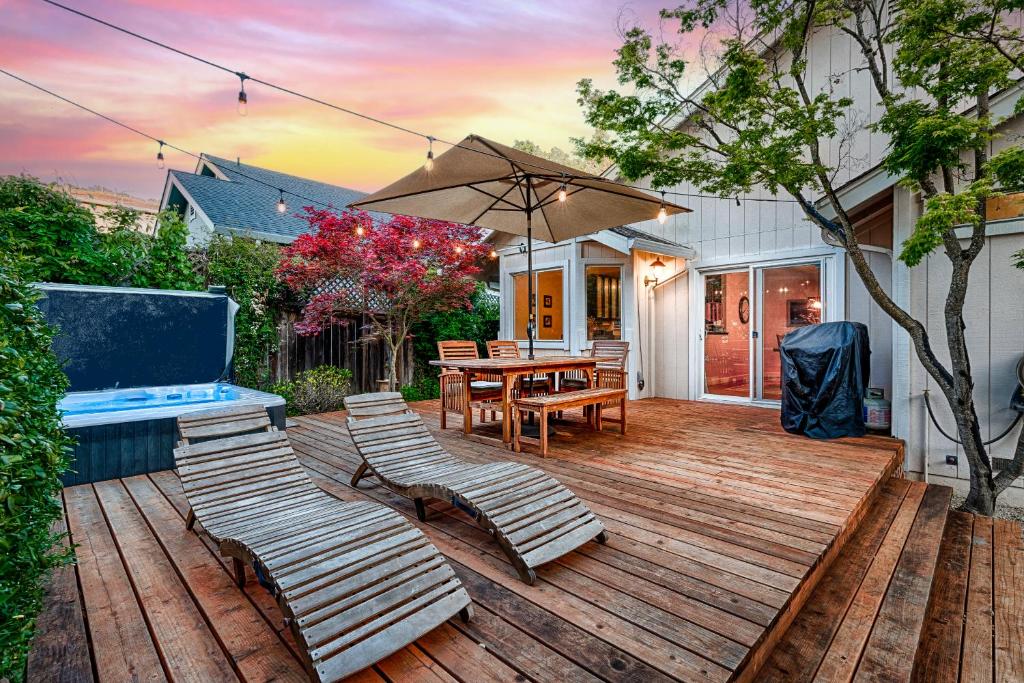 een houten terras met een tafel en stoelen en een parasol bij Spacious Oasis Hot Tub Backyard Garden 3BR/2BA in Sonoma