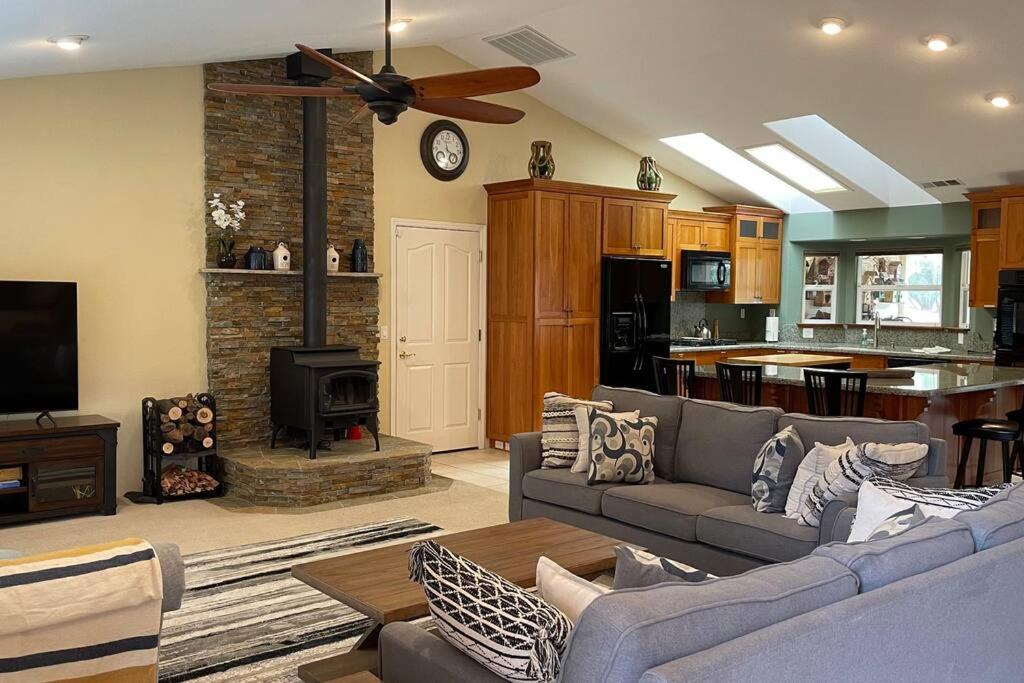 a living room with a couch and a fireplace at Mountain Haven: Wi-Fi, Luxe Views, Hot Tub close to Bass Lake, Yosemite in Oakhurst