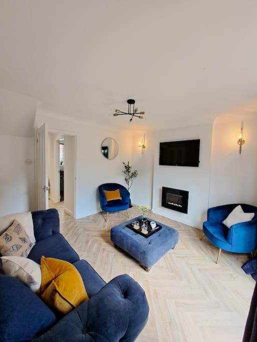 a living room with blue couches and a fireplace at Beachwood House, Serviced Accommodation in Brumby