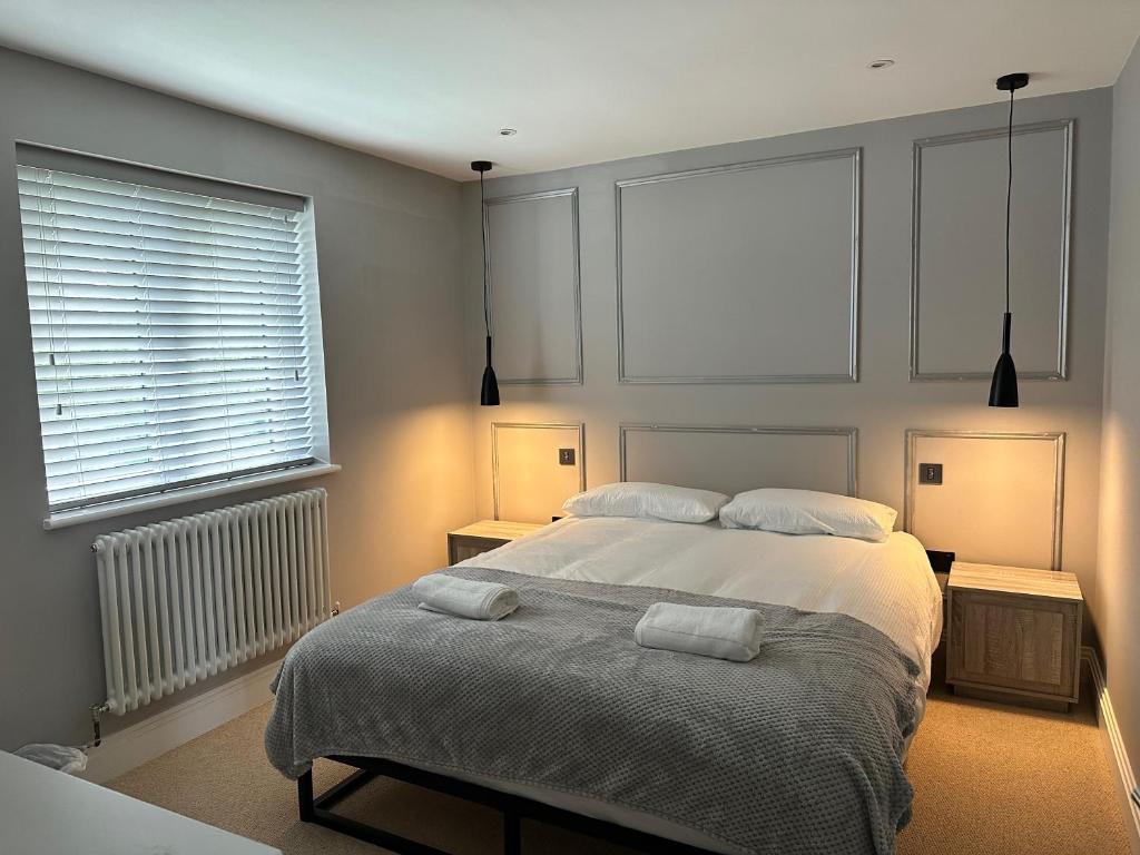 a bedroom with a bed with two towels on it at A luxury brand-new apartment in Barnet