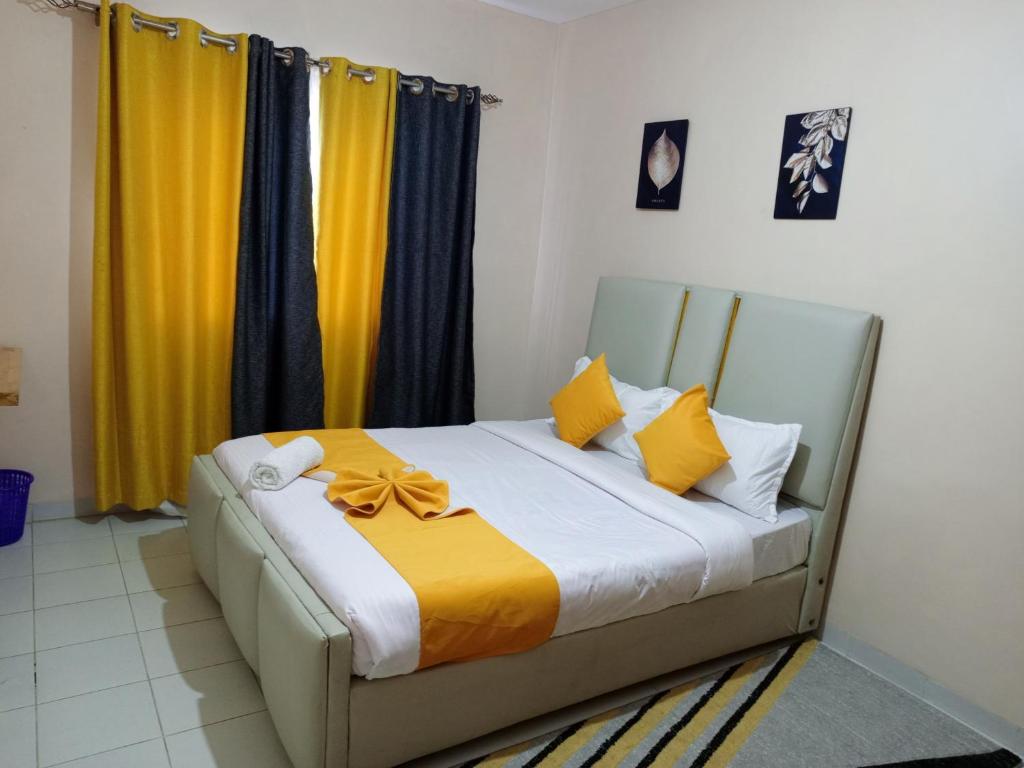 a bedroom with a bed with yellow and blue curtains at Shukrey palace in Naivasha