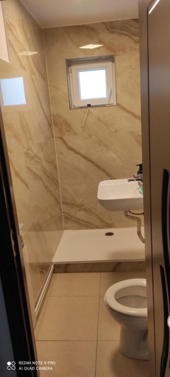 a small bathroom with a toilet and a window at Apartament Turda Cristina in Turda