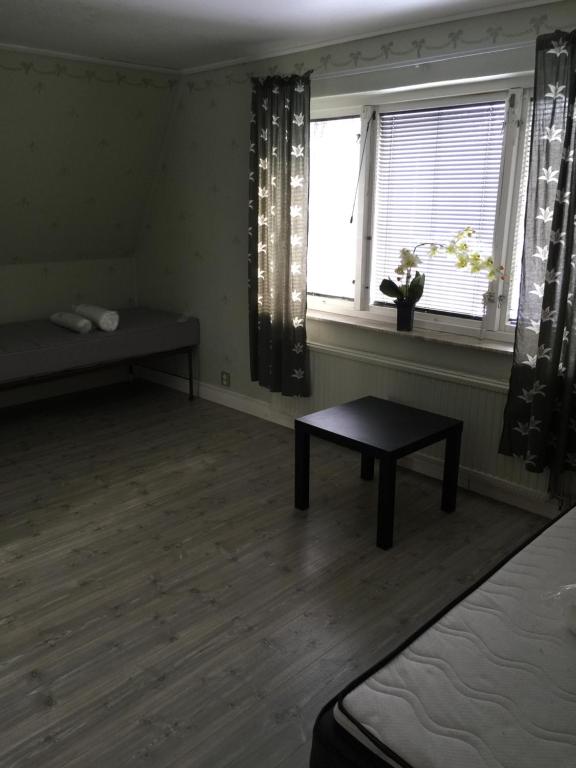 Zimmer mit einem Bett, einem Tisch und einem Fenster in der Unterkunft Mark Villan in Örebro