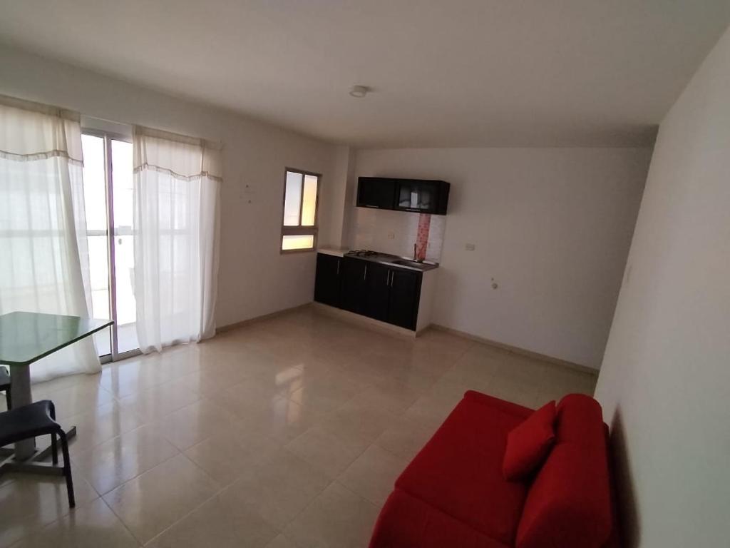 a living room with a red couch and a table at Villalba Boutique Hotel in Valledupar