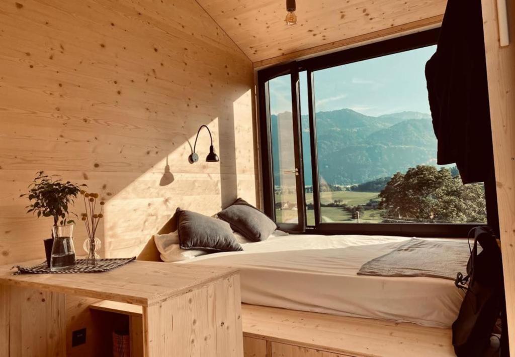 1 dormitorio con cama y ventana grande en Cabana auf dem Biohof Hornen 