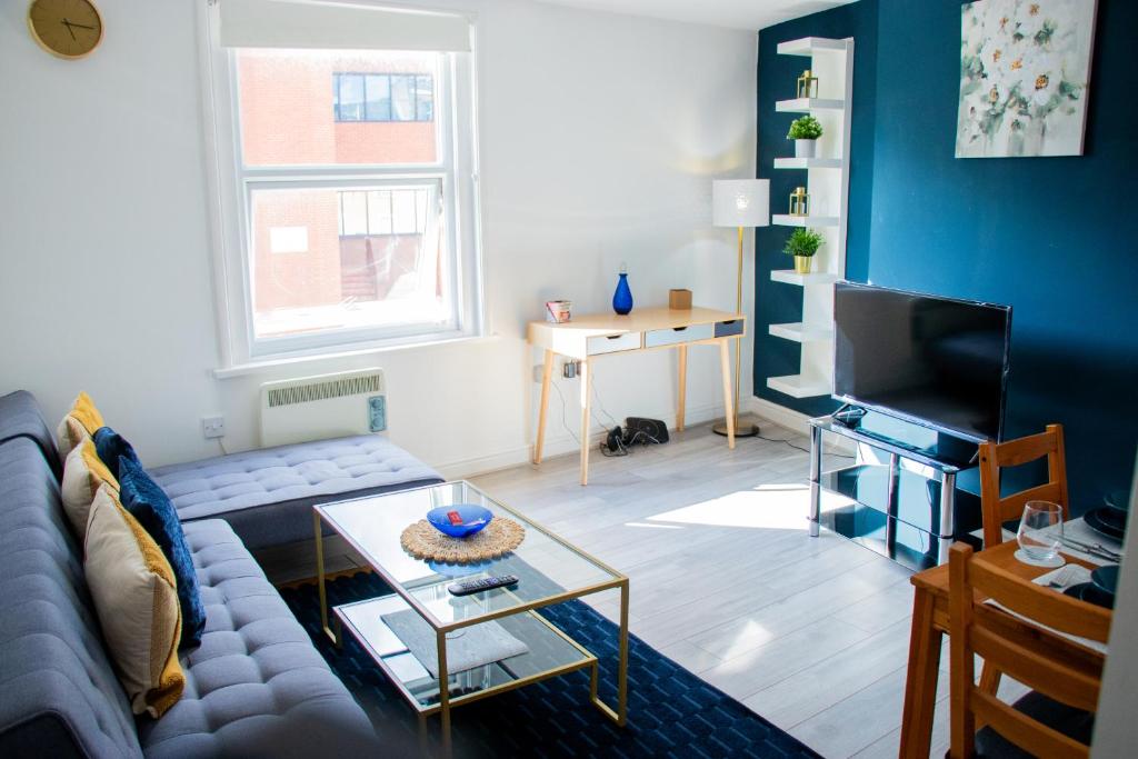 een woonkamer met een bank en een tv bij Cozy Flat Reading City Centre Available for Contractors in Reading