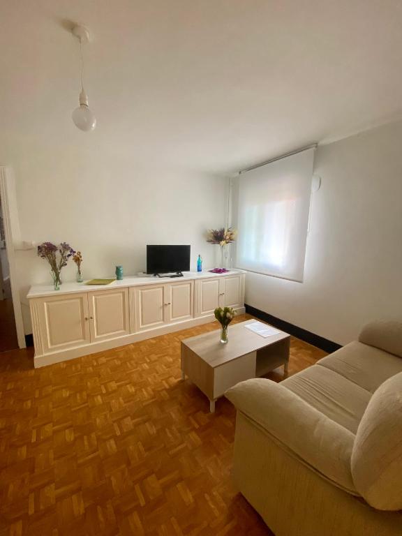 een woonkamer met een bank en een tafel bij A casa do pai in Pontevedra