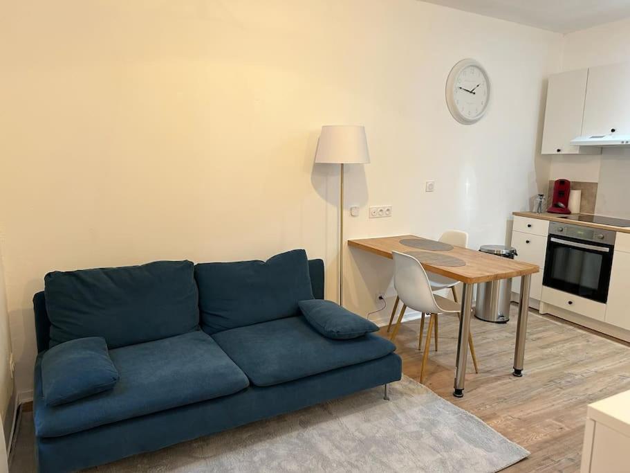 un salon avec un canapé bleu et une table dans l'établissement Au Cœur de Toulouse - Carmes, à Toulouse