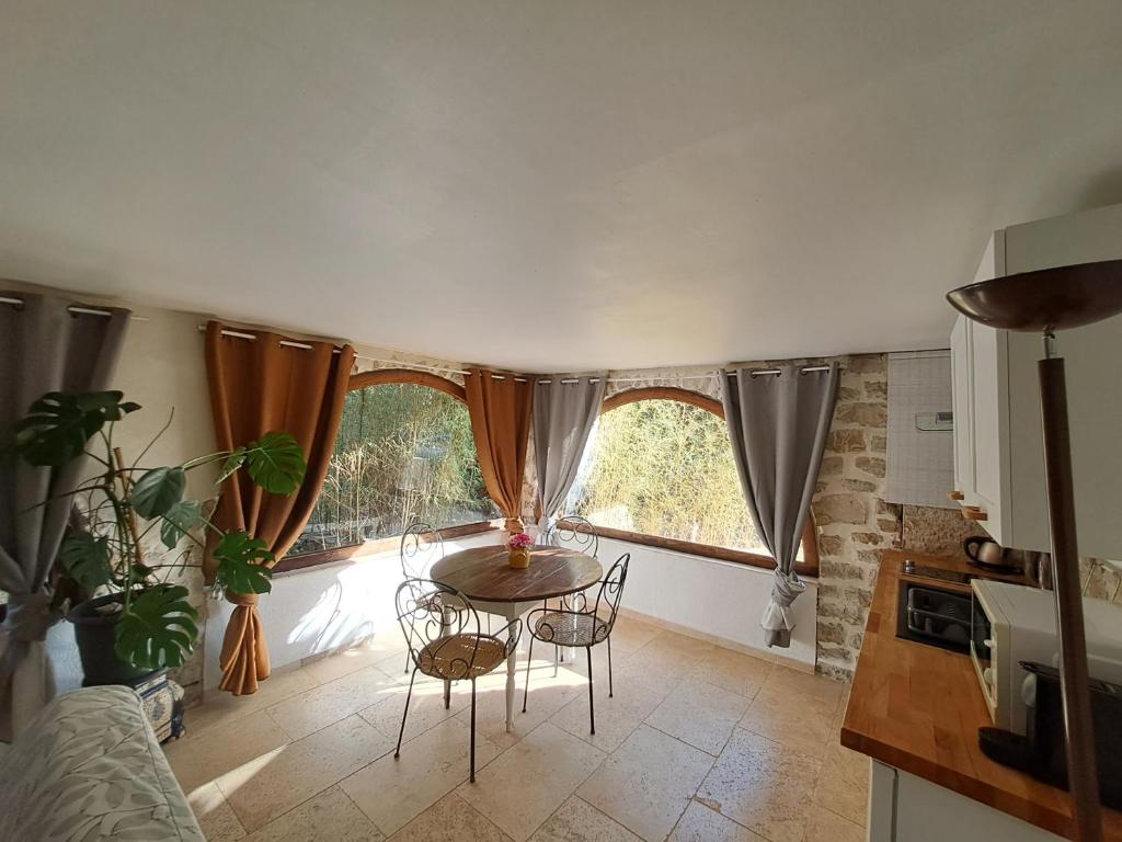 a kitchen with a table and chairs in a room at Bas de villa au chant des cigales in Lorgues