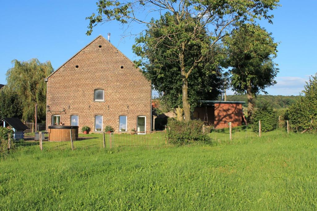 an old brick barn in a field of grass at Hof Gensterbloem 