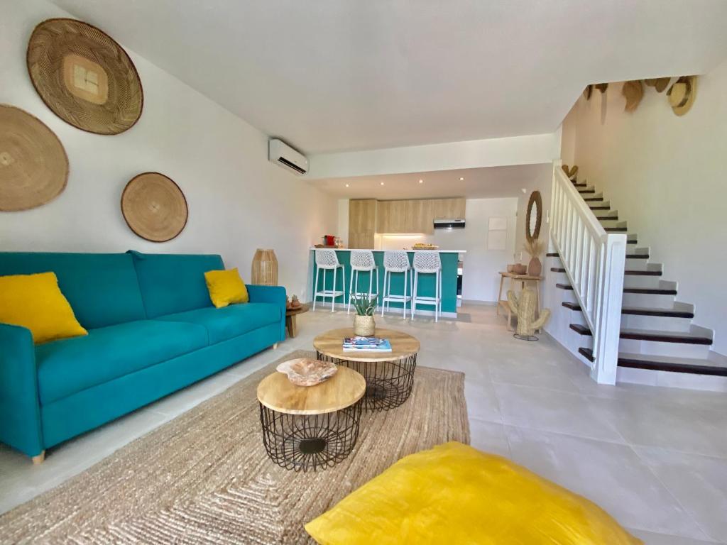 sala de estar con sofá azul y mesa en Appartement duplex Kakoon Saint Martin Anse Marcel, en Anse Marcel 