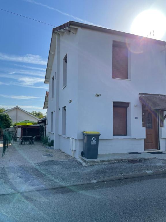 a white house with a trash can next to it at Maison de campagne in Champvans