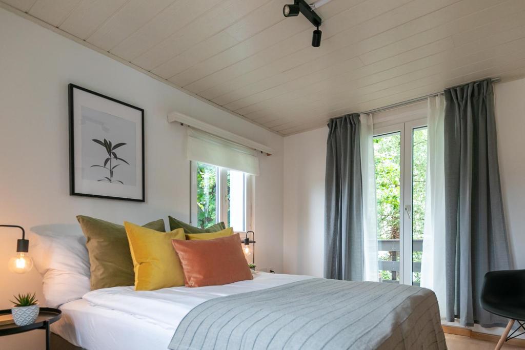 ein Schlafzimmer mit einem großen Bett mit bunten Kissen in der Unterkunft Inn Joy Apartments - Sankt Gallen West in St. Gallen