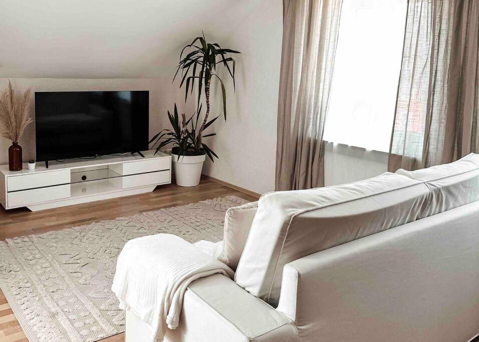 a living room with a white couch and a flat screen tv at Stilvolle Wohnung im Allgäu in Kempten