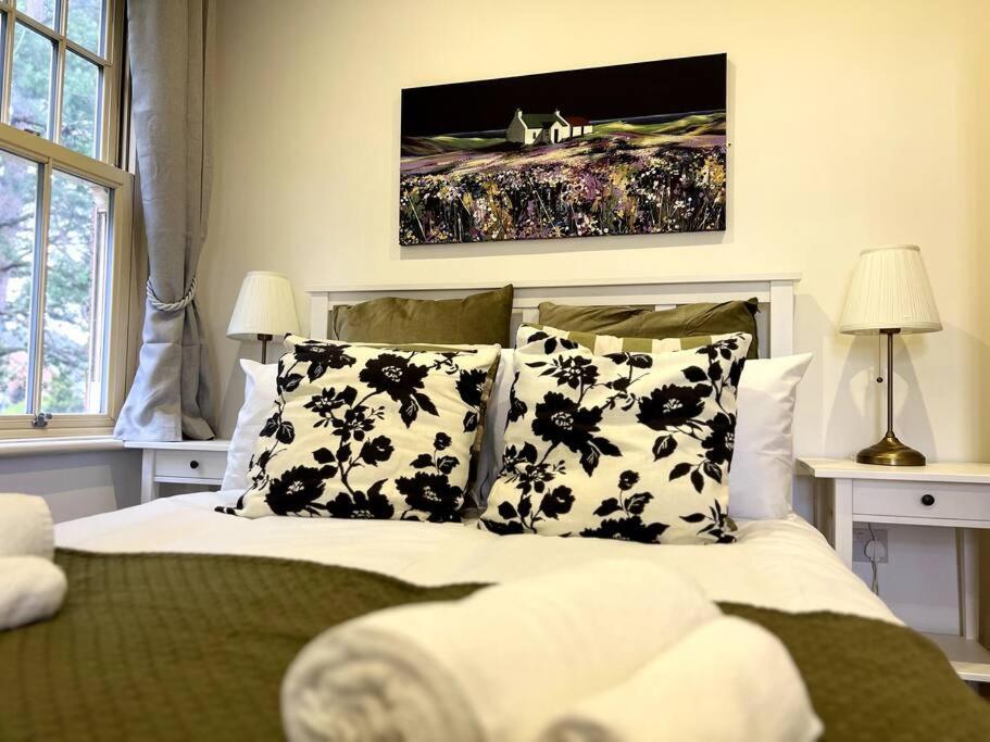 a bedroom with a bed with black and white pillows at The Burley at Scalford House in Melton Mowbray