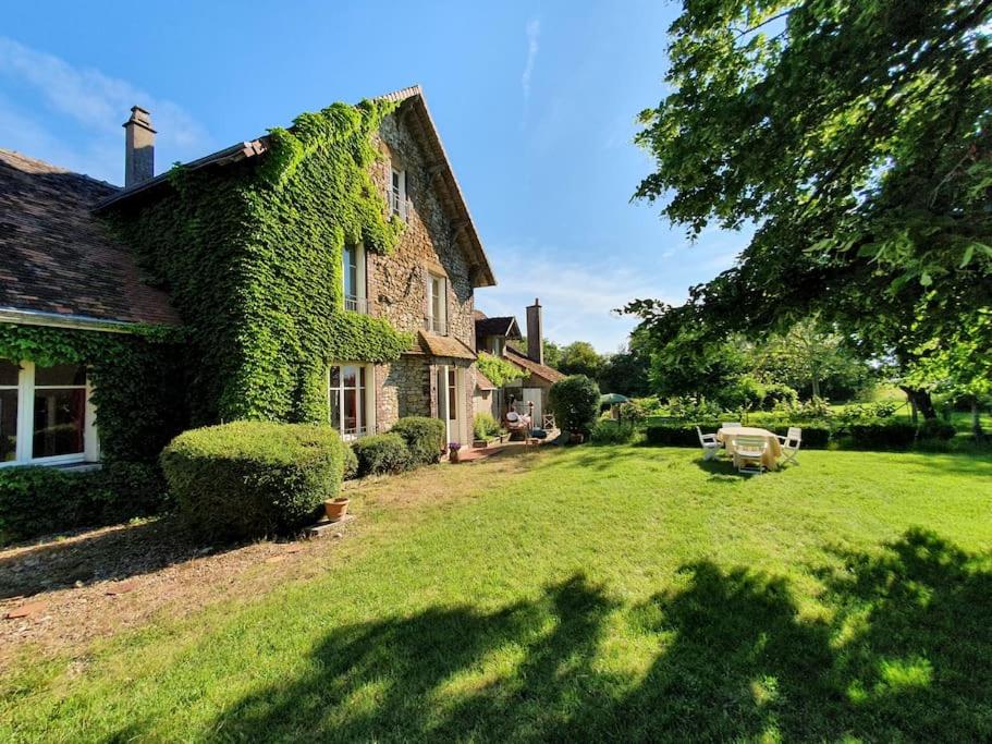an ivy covered house with a yard at Le Grand Libois - ancienne ferme 