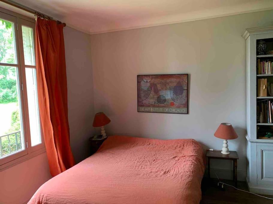 a bedroom with a red bed and a window at Le Grand Libois - ancienne ferme 