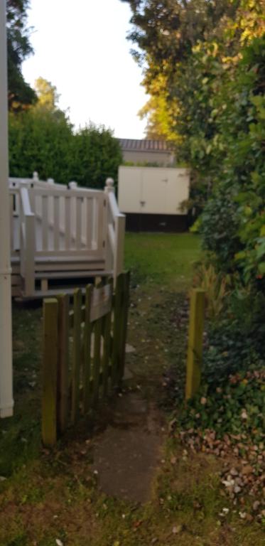 une clôture en bois dans une cour avec une maison dans l'établissement Kingsley vale, à Selsey