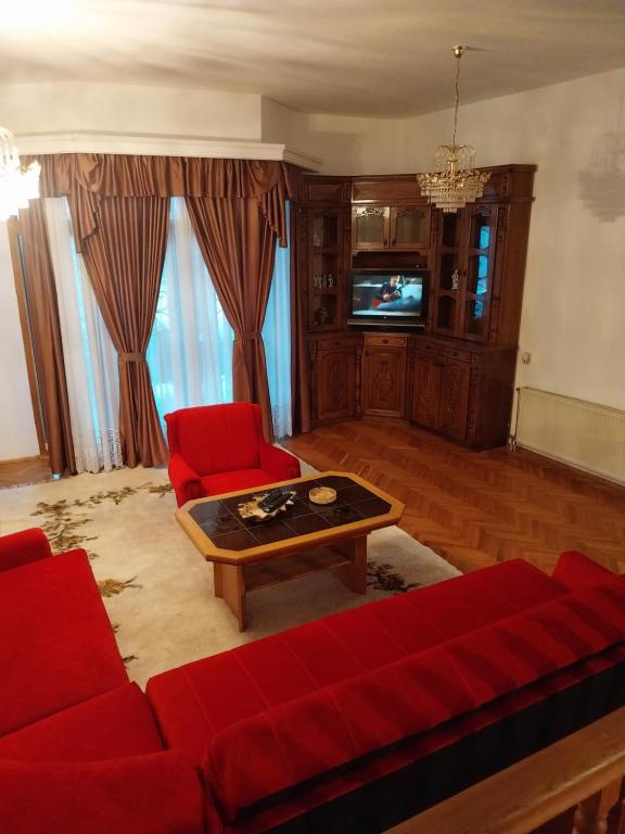 een woonkamer met een rode bank en een tv bij ENJOYMENT House 