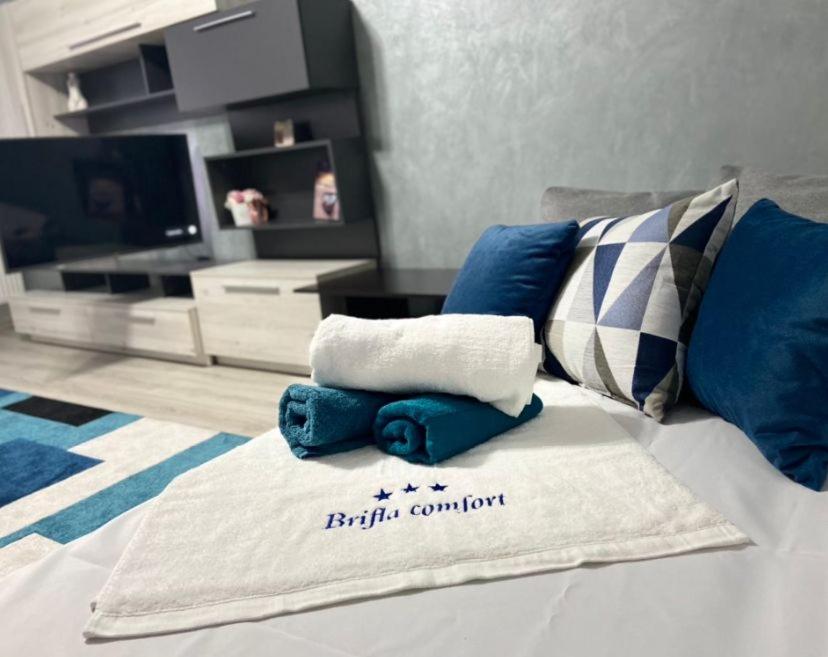 ein Bett mit blauen und weißen Handtüchern darauf in der Unterkunft Apartament BriFla Comfort Mureș in Târgu Mureș