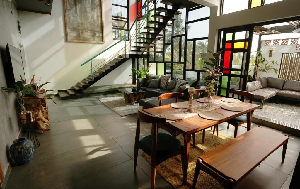 a room with a table and chairs and a couch at Lofterra Luxury Apartment in Kozhikode city, calicut in Kozhikode