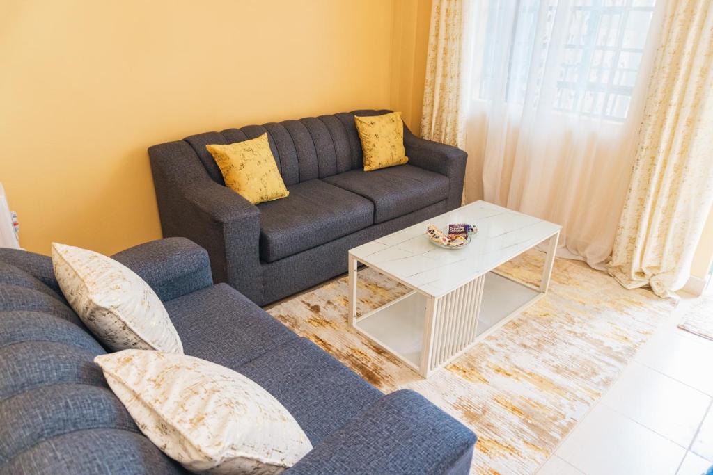 ein Wohnzimmer mit einem Sofa und einem Tisch in der Unterkunft Haven Air BnB Embu in Embu