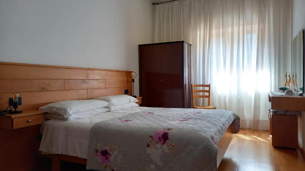 1 dormitorio con 1 cama grande y cabecero de madera en DaRenato, en Santo Stefano di Cadore