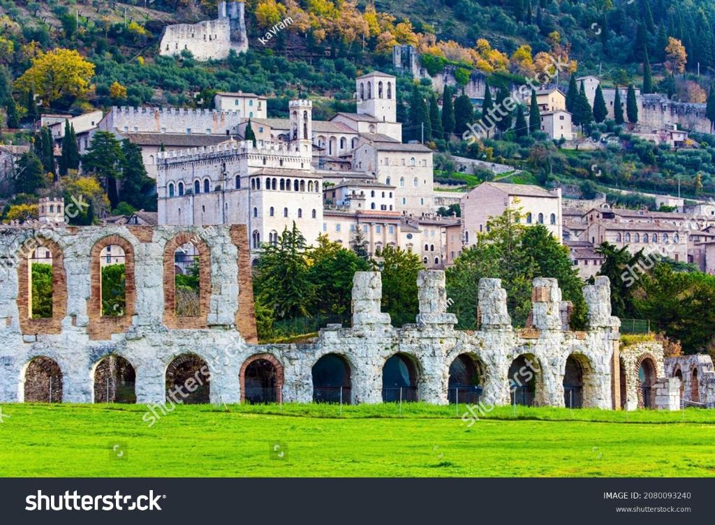 un viejo castillo en una colina con un pueblo en el fondo en Casa Stefy Gubbio Centro, en Gubbio