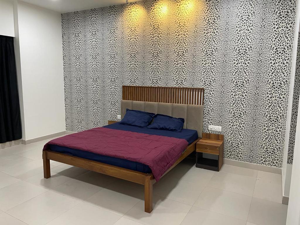 1 dormitorio con 1 cama con colcha púrpura en Royal Nest Premium-AS, en Pune