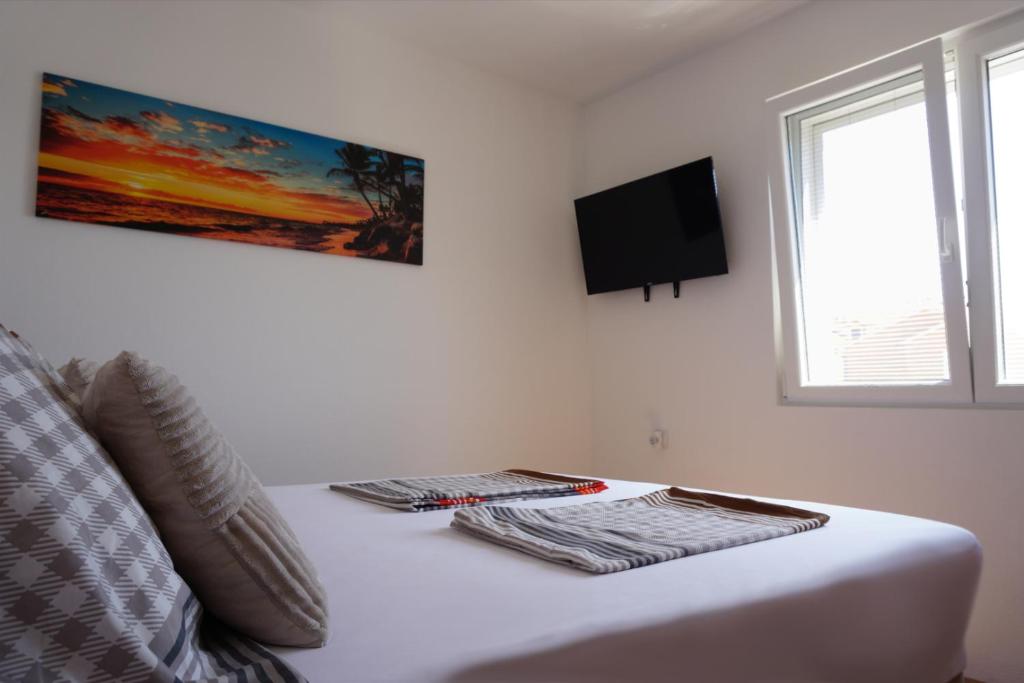 a bedroom with a bed with two towels on it at Apartmani Skledar in Vodice