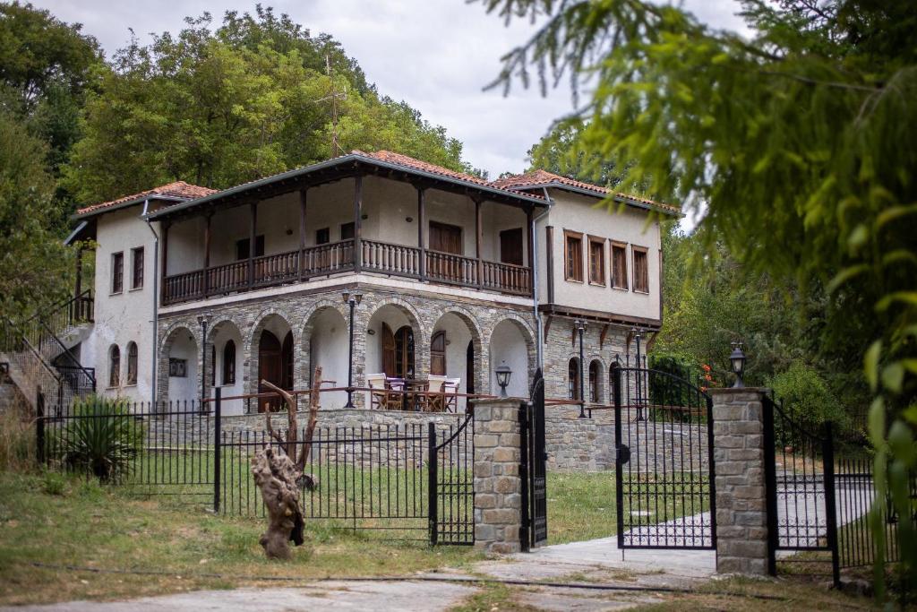 une vieille maison avec une clôture devant elle dans l'établissement Zenios Dionysos - Traditional villa, à Grevená