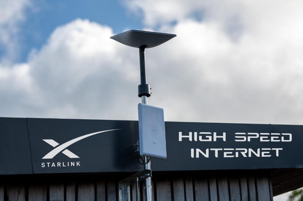 a street light next to a high speed internet sign at Luxury Glamping Cabin with Outdoor Bath on Cornish Flower Farm in Truro