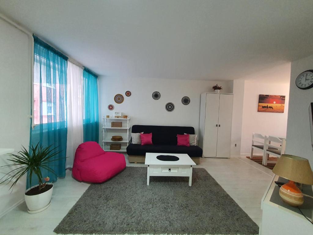 sala de estar con sofá y silla rosa en Studio apartment Sarajevo, en Sarajevo