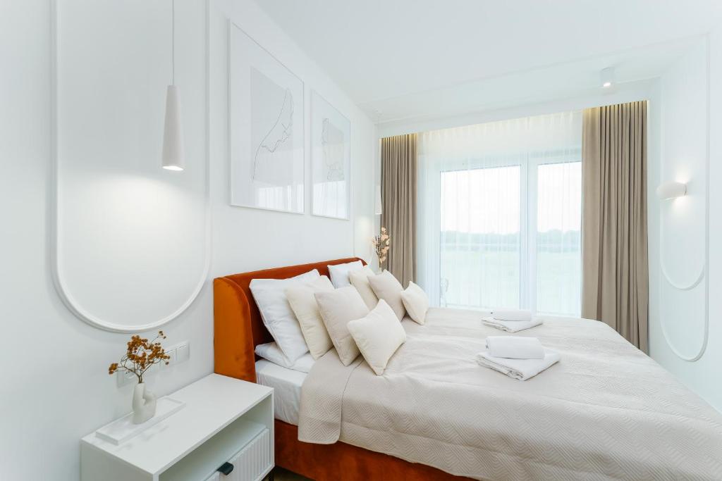 科沃布熱格的住宿－Apartament Premium D307 Polanki Aqua，白色卧室配有一张带白色枕头的大床