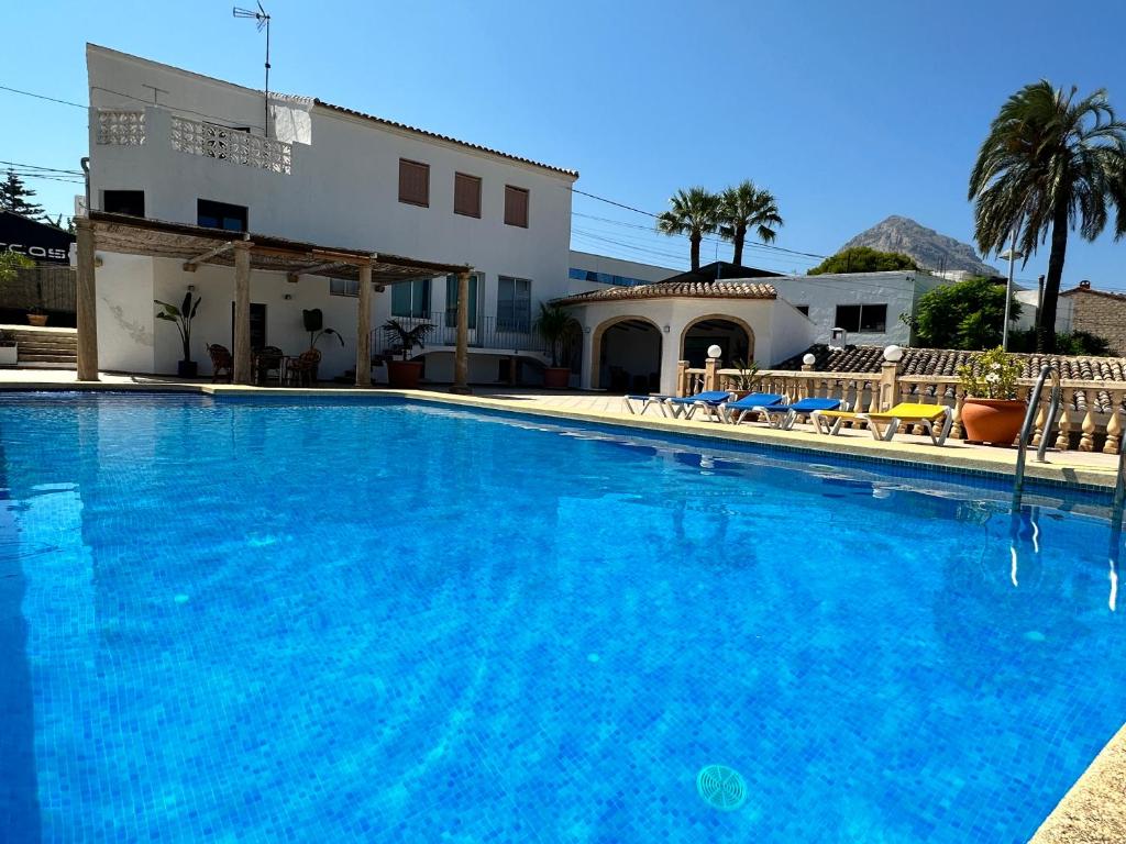 una grande piscina blu di fronte a una casa di Casa Maria Cecília a Jávea