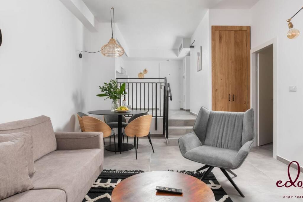 a living room with a couch and chairs and a table at דירה משפחתית במיקום מנצח - By Edomlux in Eilat