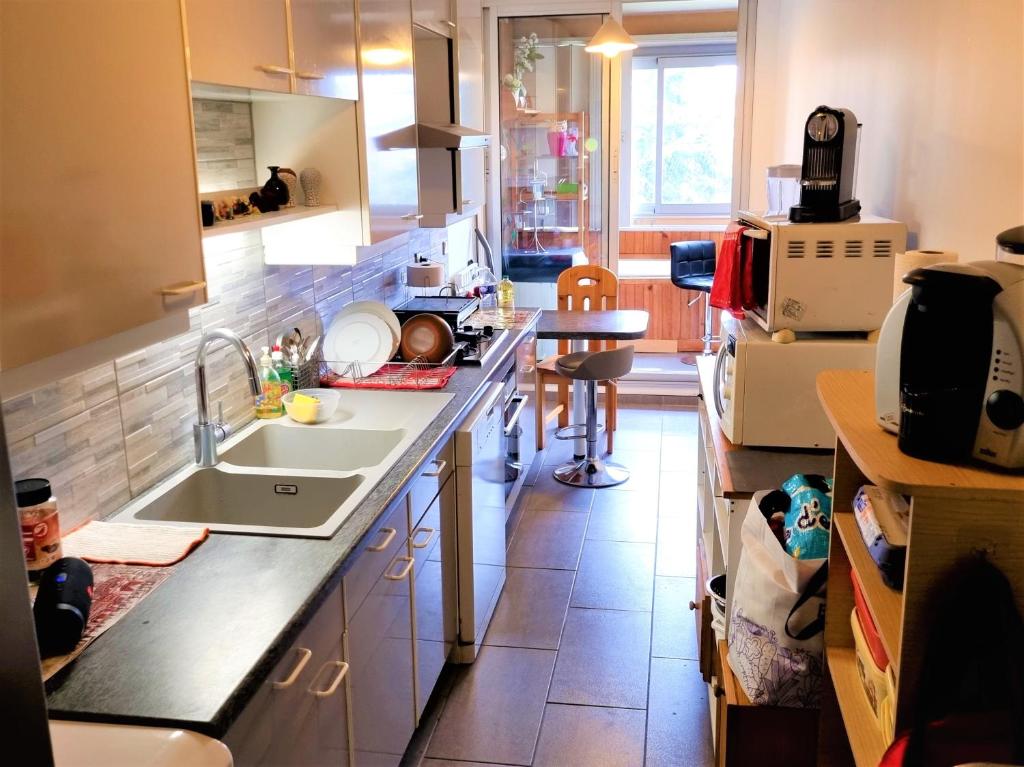 een keuken met een spoelbak en een aanrechtblad bij Superbe chambre à clés Paris in Sartrouville