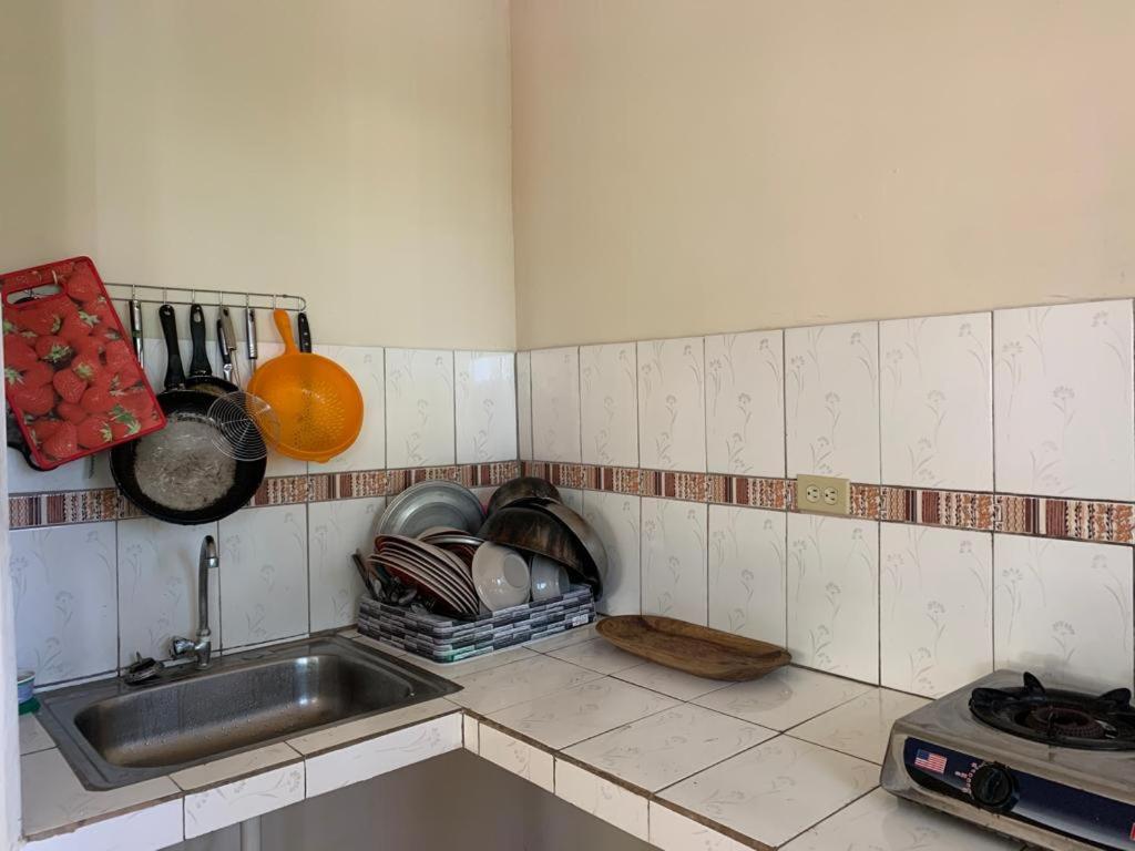 um balcão de cozinha com um lavatório e utensílios em Hostal Aguas Verdes em Santa Catalina